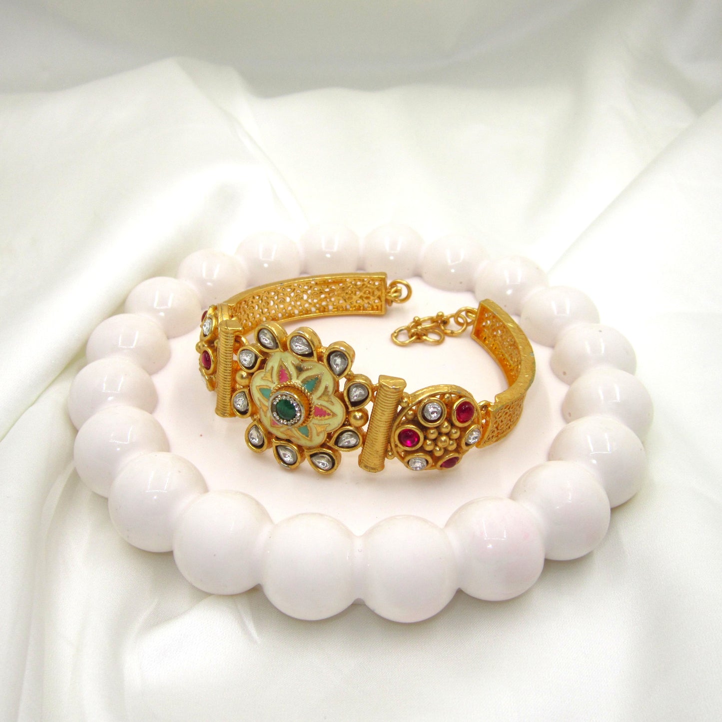 Avani Meena Ethnic & Traditional Golden Bracelet by ENAVA featuring floral Meenakari design, kundan-style stones, ruby and green accents, traditional Rajwadi heritage jewellery with elegant golden finish for weddings and festive wear.