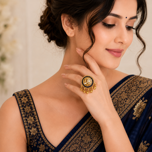 Neeltara Peacock Designer Ghungroo Statement Ring by Enava featuring an adjustable antique gold statement ring with peacock motif, royal blue enamel detailing, Kundan-inspired stones, pearl accents and decorative ghungroo charms, ideal for wedding, festive and ethnic wear.