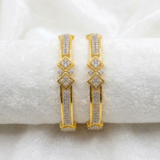 Prestige Gold Plated CZ AD Kada Bangles by ENAVA featuring sparkling clear white Cubic Zirconia American Diamond stones with elegant geometric motifs and premium gold plating. Luxury bridal kada bangles perfect for weddings, receptions, festive occasions, party wear, and designer jewellery collections.