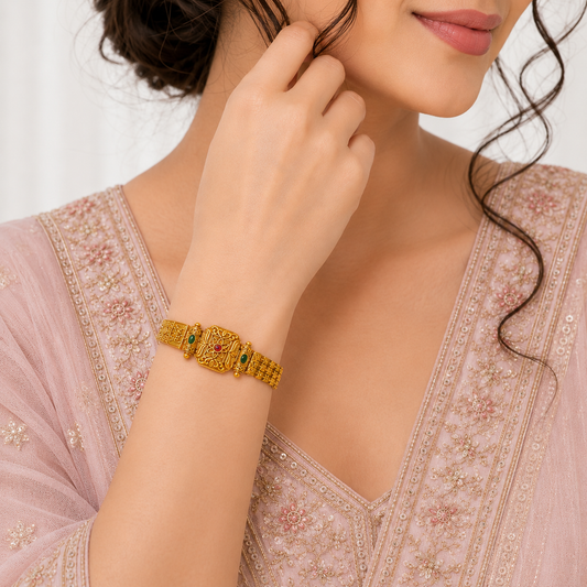 Rajsi Veda Ethnic & Traditional Rajwadi Bracelet by ENAVA featuring an antique gold finish, ruby red centre stone, matching green stone accents, intricate floral engravings, and traditional Rajwadi craftsmanship for weddings and festive wear.