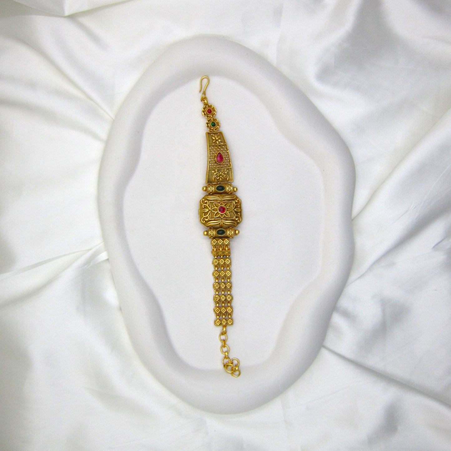 Rajsi Veda Ethnic & Traditional Rajwadi Bracelet by ENAVA featuring an antique gold finish, ruby red centre stone, matching green stone accents, intricate floral engravings, and traditional Rajwadi craftsmanship for weddings and festive wear.