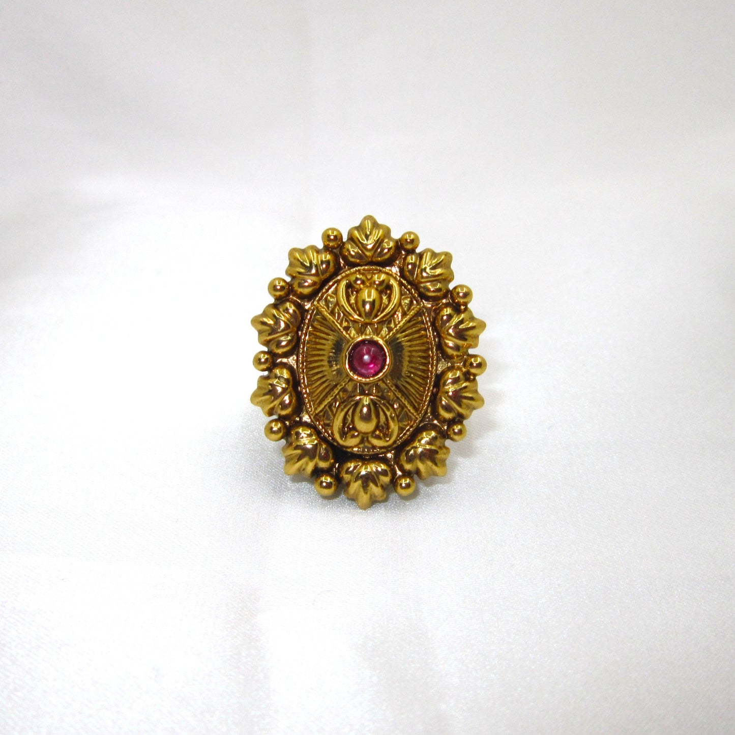 Ruby Bloom Sunburst Antique Ring by Enava with ruby red glass stone, antique golden finish, vintage sunburst floral design, adjustable ethnic statement ring for weddings, festive wear, traditional Indian jewellery, and heritage-inspired fashion.