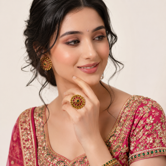 Varnika Temple Ethnic & Traditional Antique Finish Ring by Enava featuring ruby pink teardrop stones, emerald green centre stone, antique gold finish, adjustable temple-inspired statement ring for weddings, festivals, poojas, and ethnic occasions.