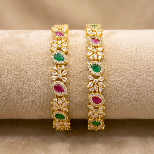 Zirconia Blossom AD Kada Gold Plated Bangles by ENAVA featuring sparkling clear white Cubic Zirconia AD stones in an elegant blossom-inspired design. Premium gold plated bridal kada bangles perfect for weddings, festive occasions, party wear, and ethnic jewellery collections.
