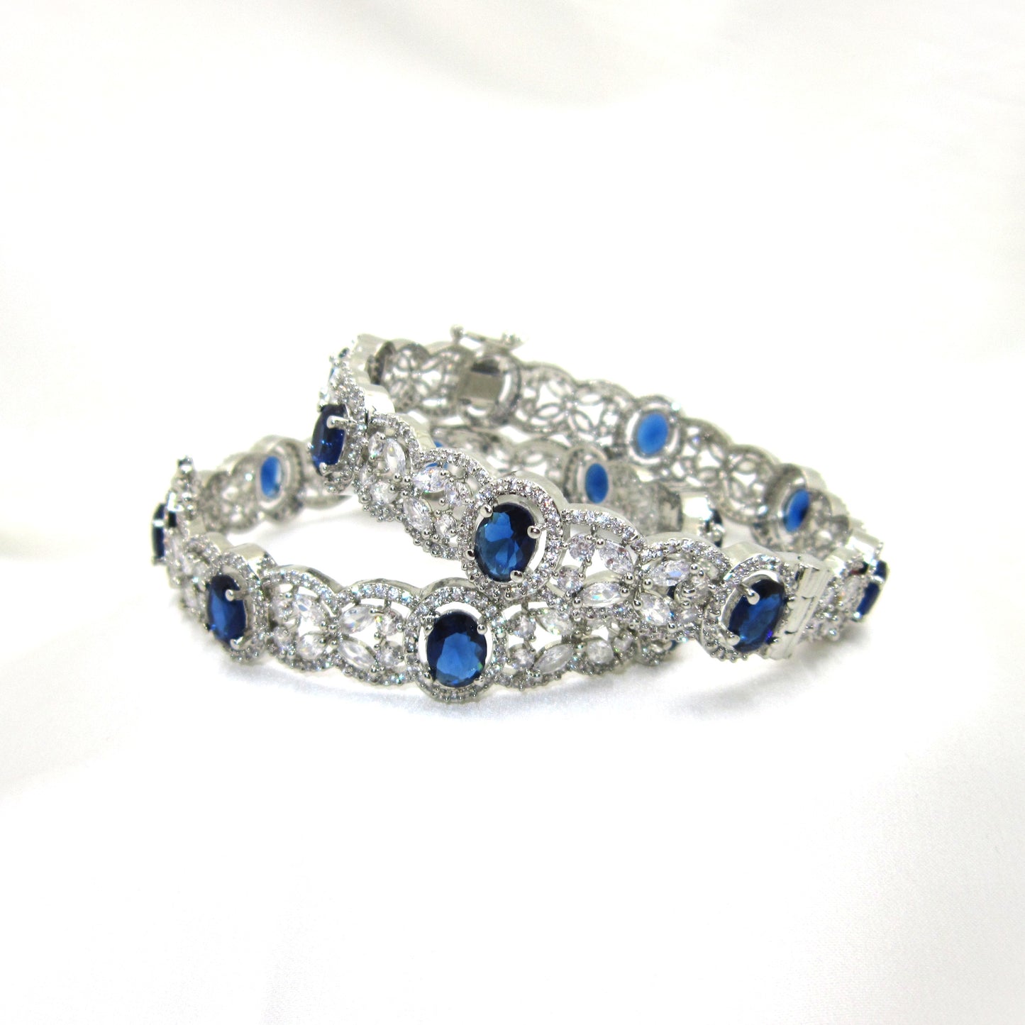 Celestial Blue Victoria AD Silver Plated Bangles by ENAVA featuring sparkling American Diamonds, floral detailing, and elegant blue stones. Premium silver-plated designer bangles for weddings, festive occasions, receptions, and party wear.