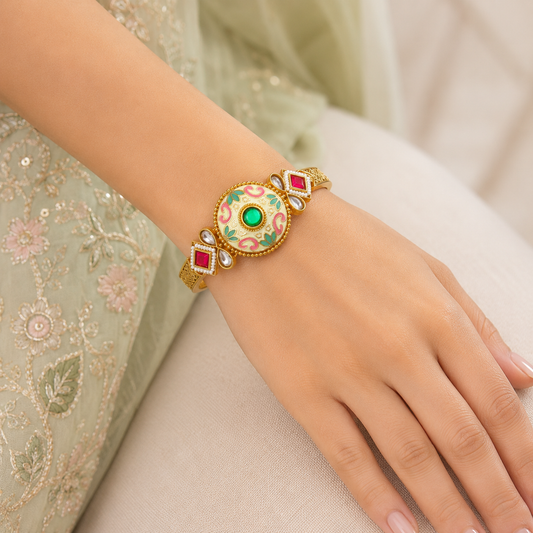 Kalashini Emerald Green Enamel Bracelet by Enava featuring a circular Kundan centerpiece with hand-painted emerald green Meenakari enamel, antique gold finish, adjustable closure, and a premium ethnic statement bracelet for weddings, festive celebrations, and traditional wear.