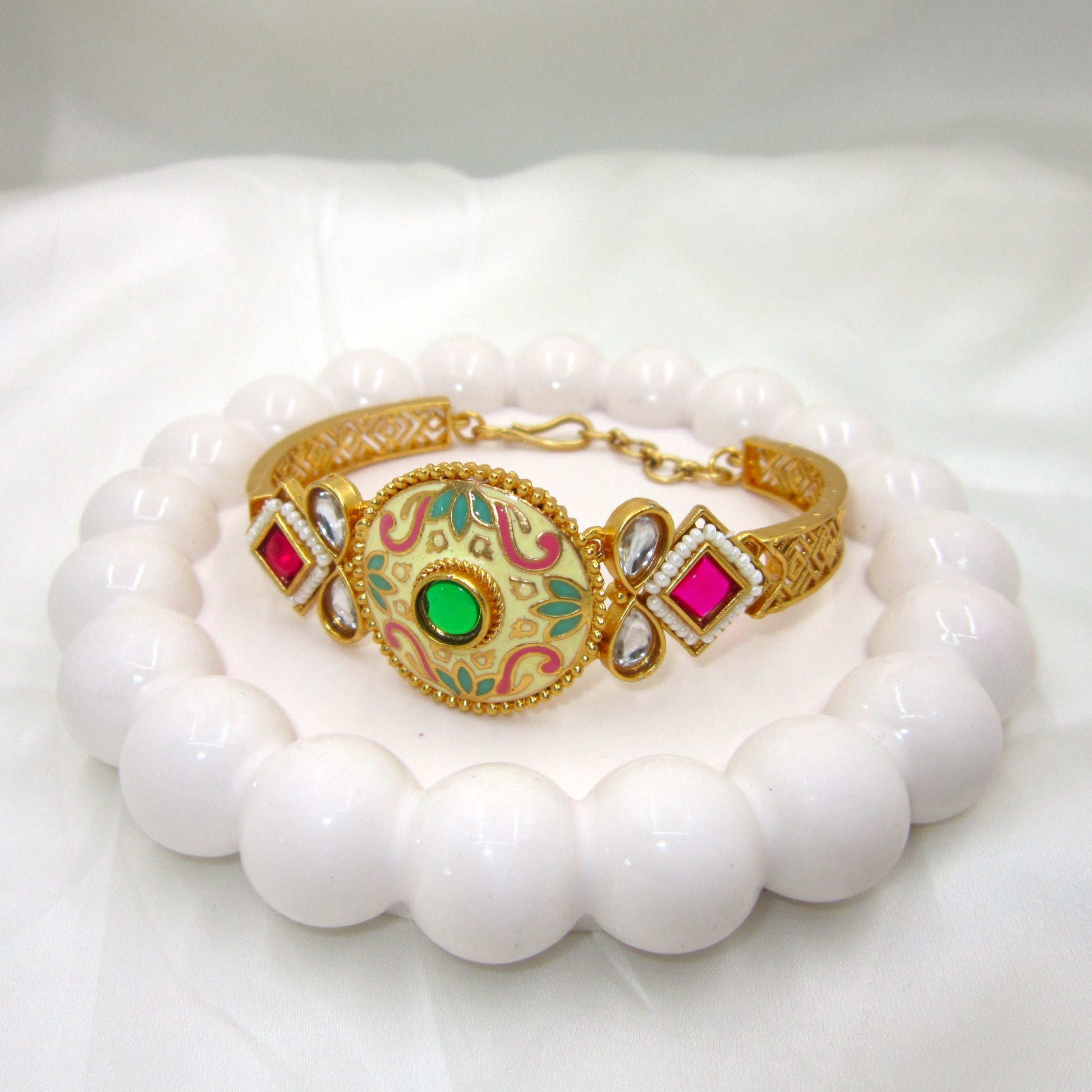 Kalashini Emerald Green Enamel Bracelet by Enava featuring a circular Kundan centerpiece with hand-painted emerald green Meenakari enamel, antique gold finish, adjustable closure, and a premium ethnic statement bracelet for weddings, festive celebrations, and traditional wear.