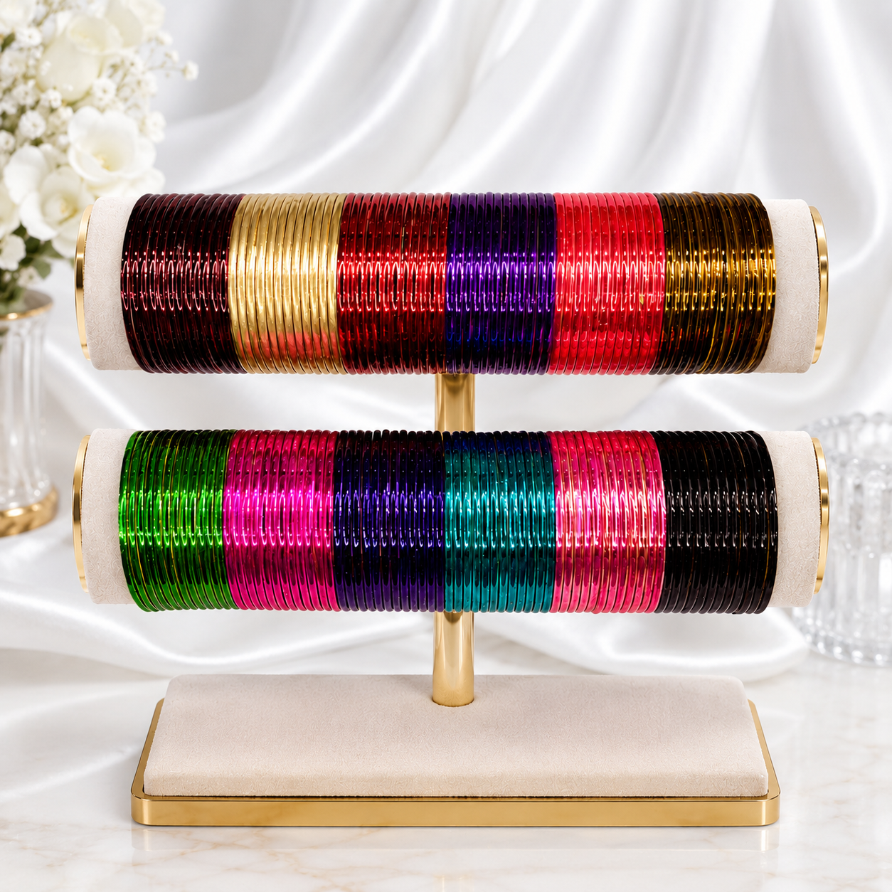 A jewelry display stand holding two horizontal rods filled with colorful bangles. The bangles are arranged in vertical stripes of metallic and glossy shades including gold, red, purple, green, teal, pink, and black.