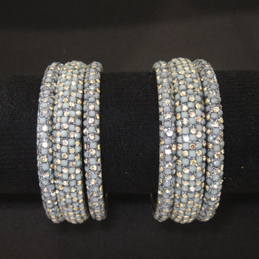 Meher Grey Festive Bangle Set with 2 kada bangles and 4 side bangles featuring grey detailing, golden accents and sparkling stones by ENAVA