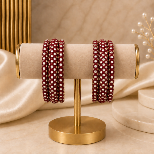 Meher Maroon Festive Bangle Set with 2 kada bangles and 4 side bangles featuring maroon detailing, golden accents and sparkling stones by ENAVA