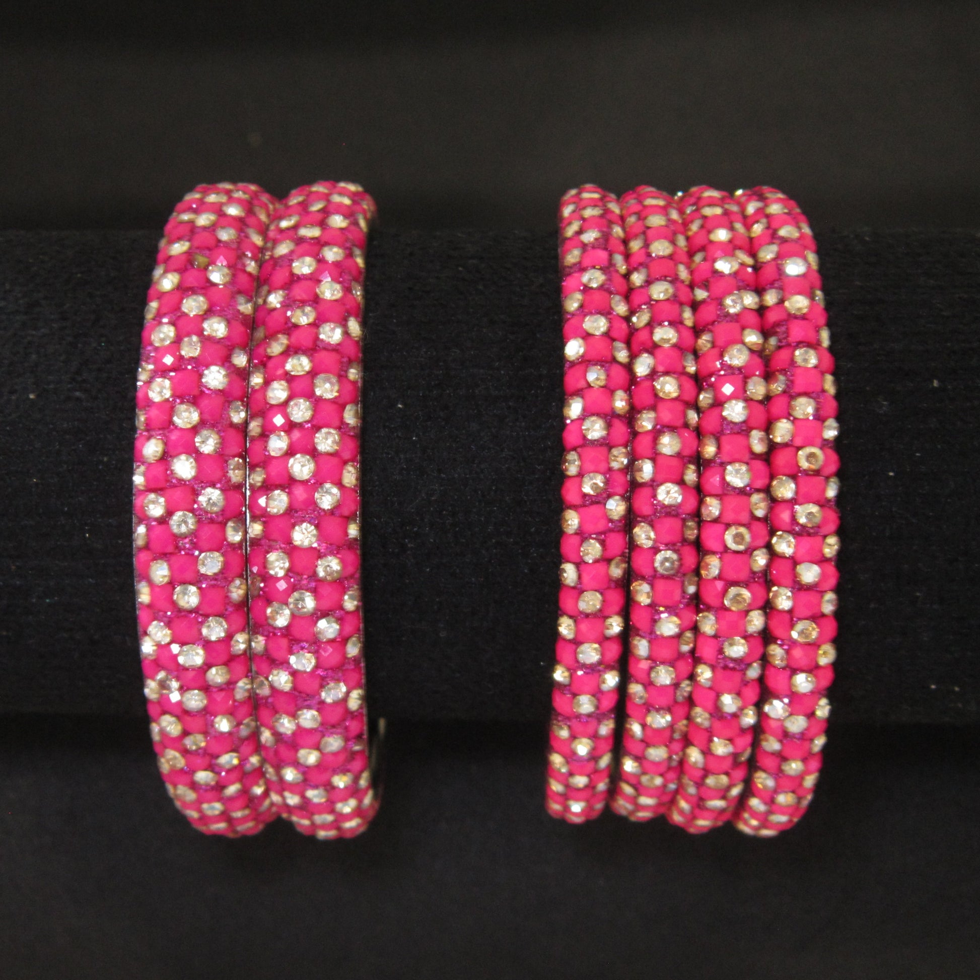 Meher Rani Pink Festive Bangle Set with 2 kada bangles and 4 side bangles featuring rani pink detailing, golden accents and sparkling stones by ENAVA