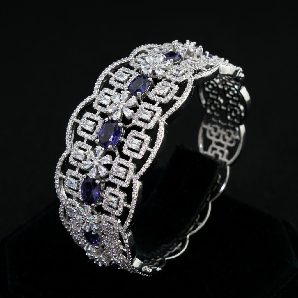 An ornate silver-tone cuff bracelet featuring large oval and marquise-cut purple gemstones and pavé-set clear stones, displayed on a black velvet surface against a black background.