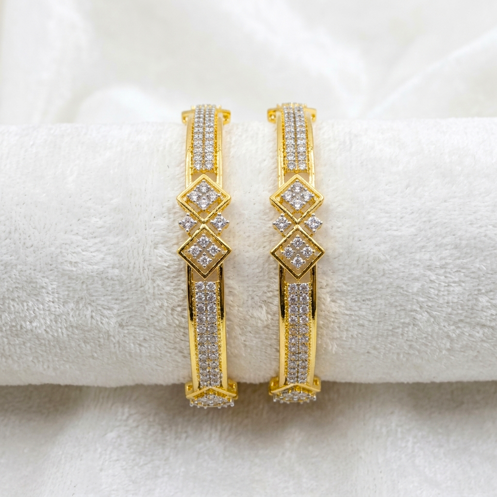 Prestige Gold Plated CZ AD Kada Bangles by ENAVA featuring sparkling clear white Cubic Zirconia American Diamond stones with elegant geometric motifs and premium gold plating. Luxury bridal kada bangles perfect for weddings, receptions, festive occasions, party wear, and designer jewellery collections.