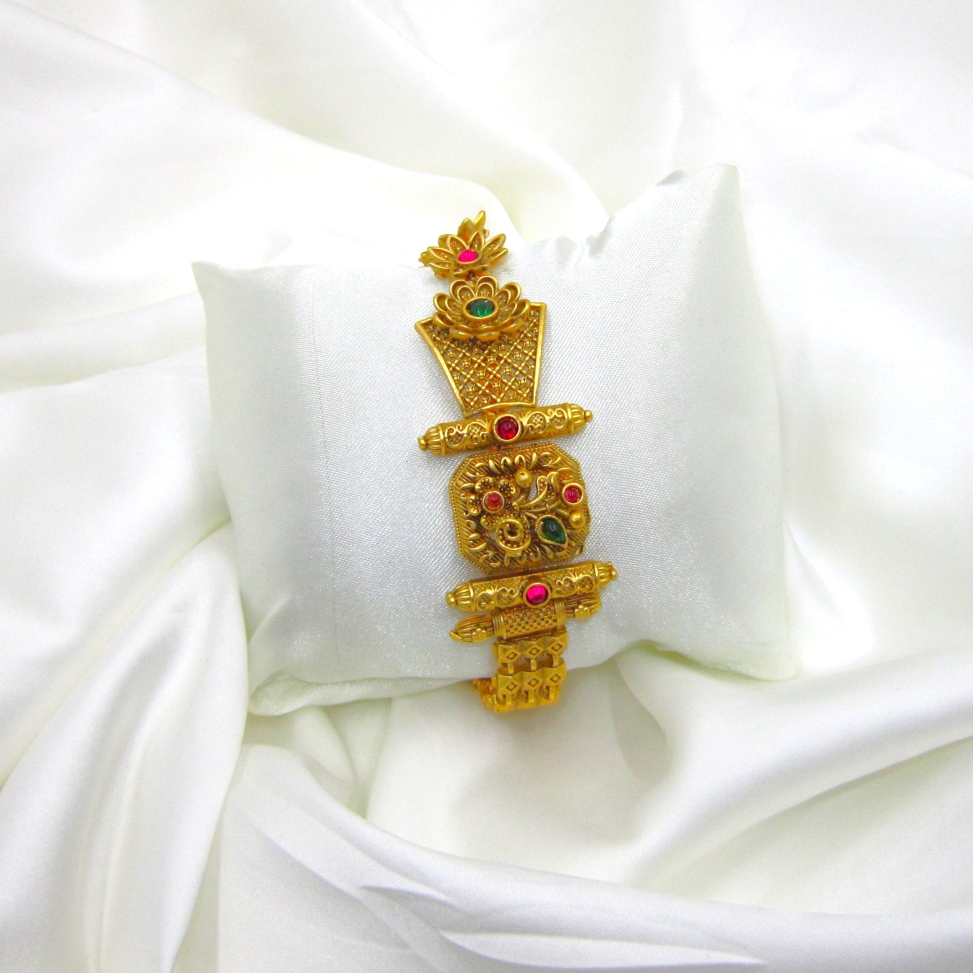 Rajaswi Floral Heritage Bracelet by Enava featuring an antique gold floral design with ruby pink and emerald green stones, intricate heritage detailing, adjustable chain closure, and a premium ethnic statement bracelet for weddings and festive occasions.