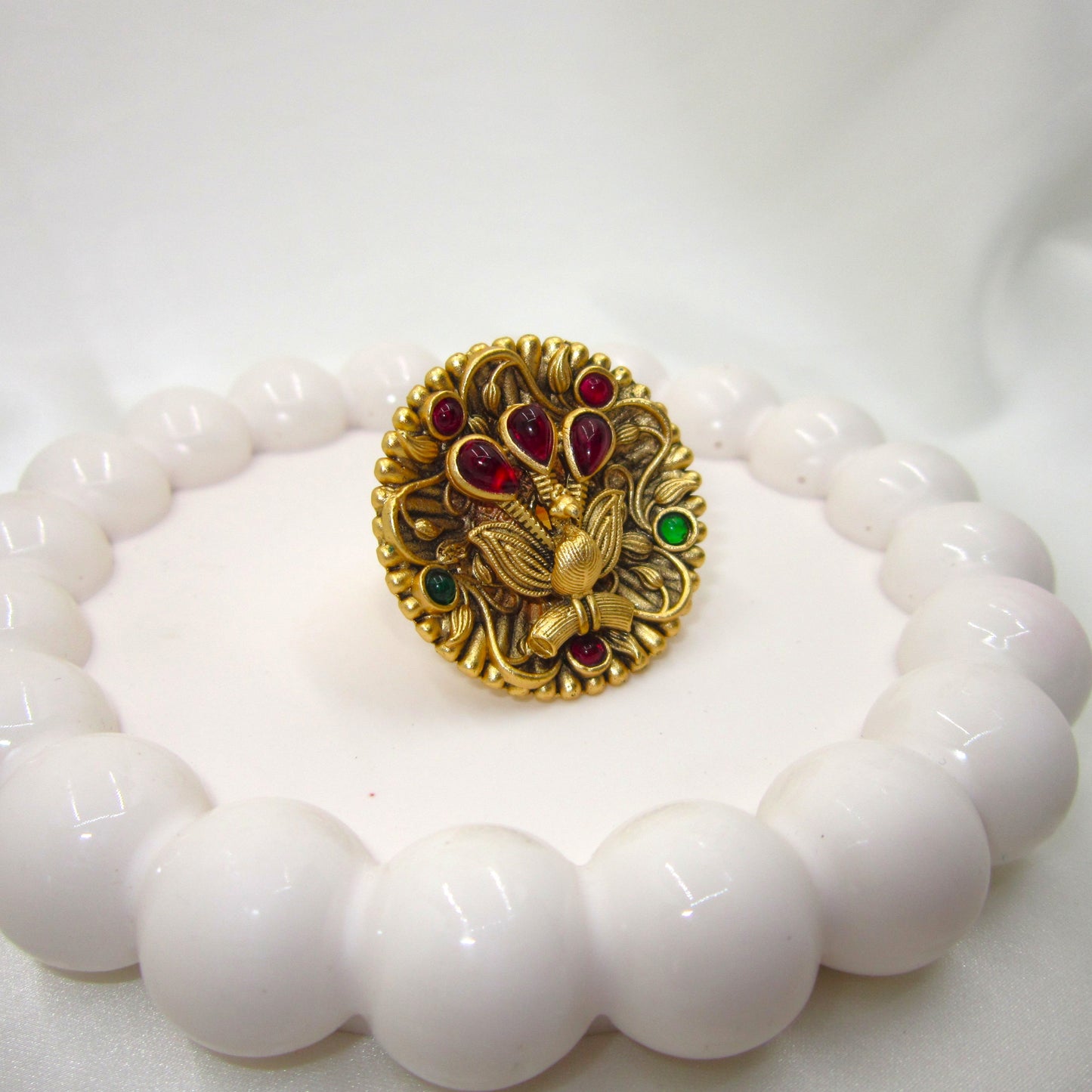 Rajmayuri Heritage Antique Golden Finish Ethnic Ring by Enava featuring a handcrafted 3D peacock design with antique gold finish, ruby-red and emerald-green stones, premium statement ethnic ring for bridal, festive, wedding, and traditional wear.