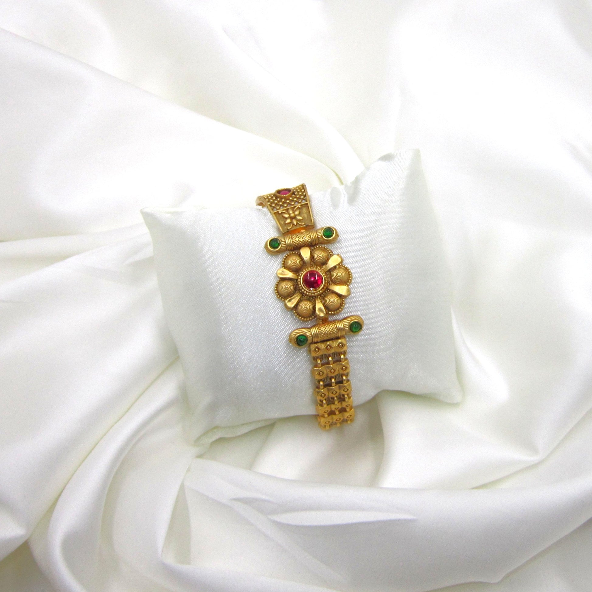 Heritage Blossom Rajwadi Antique Bracelet by ENAVA featuring a floral centerpiece, antique gold finish, ruby and emerald-inspired stone accents, traditional Rajwadi heritage jewellery bracelet for weddings, Mehendi, Sangeet, festivals, and ethnic celebrations.