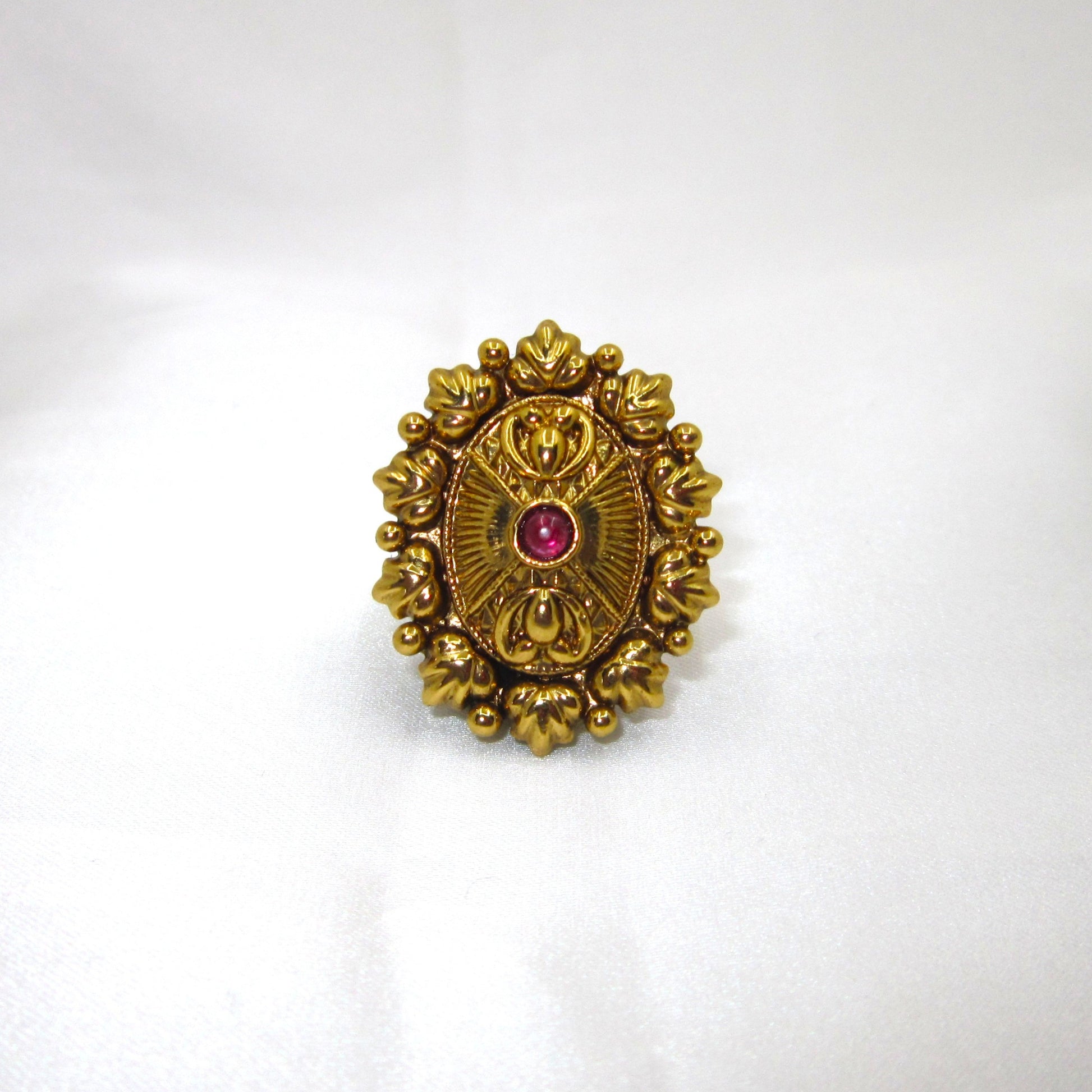 Ruby Bloom Sunburst Antique Ring by Enava with ruby red glass stone, antique golden finish, vintage sunburst floral design, adjustable ethnic statement ring for weddings, festive wear, traditional Indian jewellery, and heritage-inspired fashion.