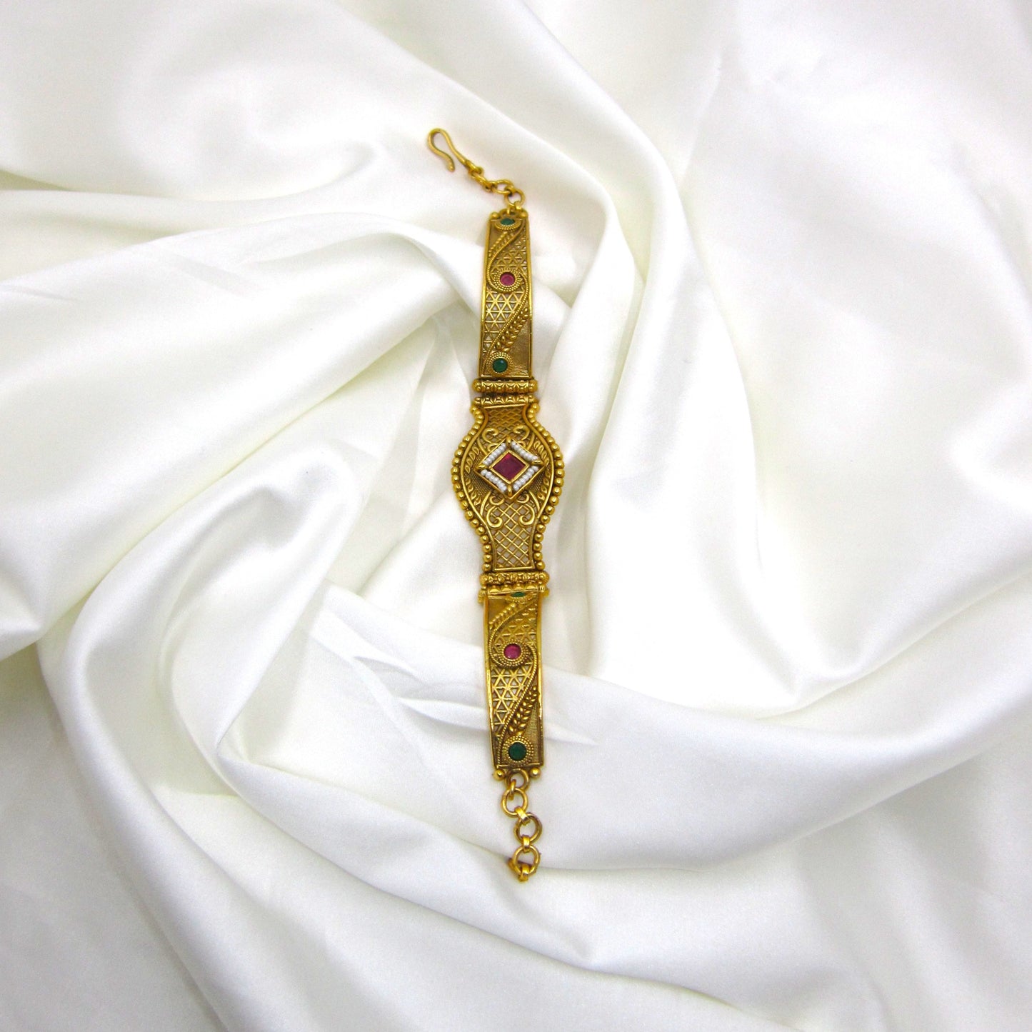 Shagun Spark Rajwadi Bracelet by ENAVA featuring antique gold finish, ruby red centerpiece stone, emerald green accents, and intricate Rajwadi heritage craftsmanship for weddings and festive wear.
