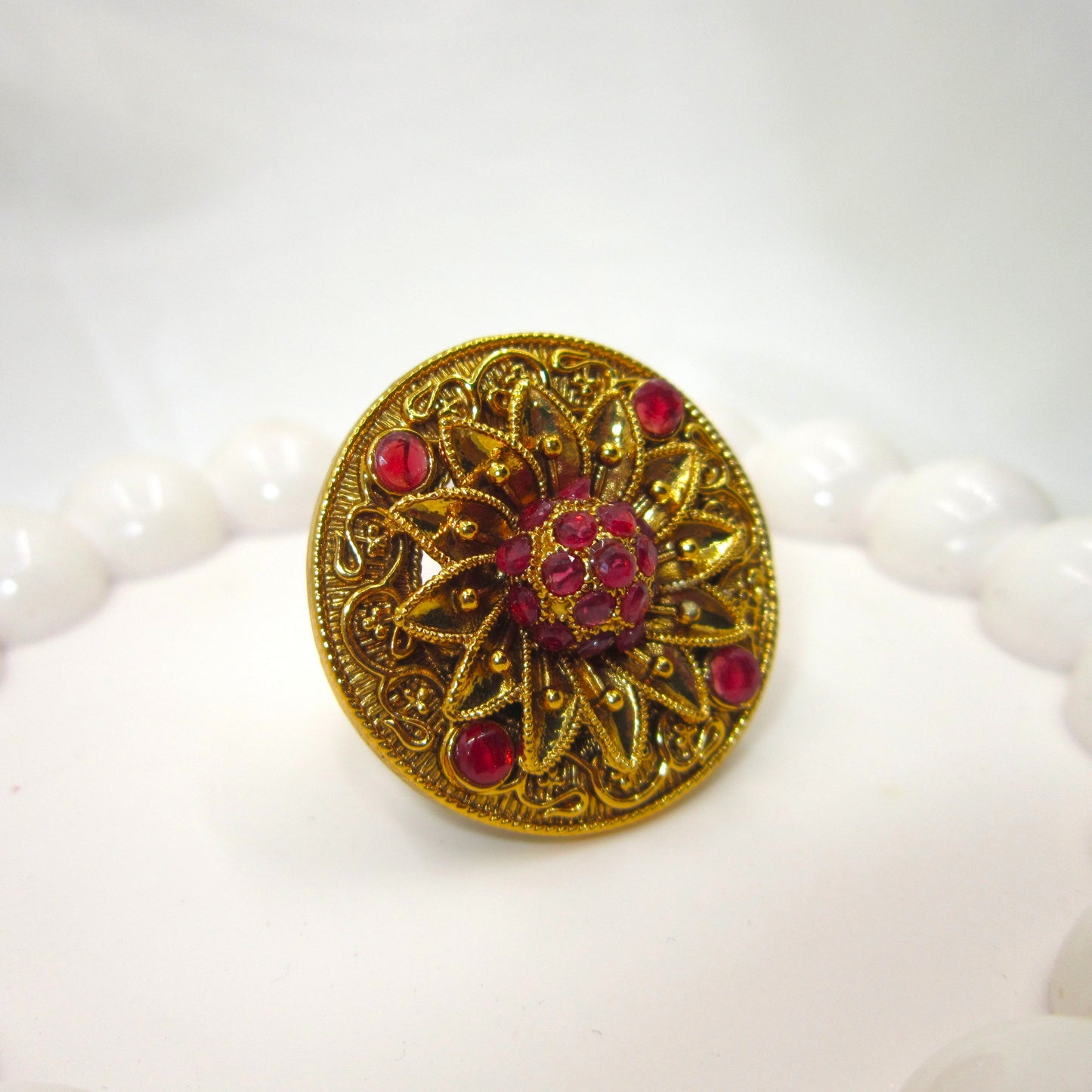 Swarna Petals Ruby Pink Antique Finish Ring by Enava featuring a handcrafted floral sunburst design with antique gold finish and ruby pink stones, traditional ethnic statement ring for women, ideal for weddings, festive wear, Rajwadi jewellery, and bridal accessories.