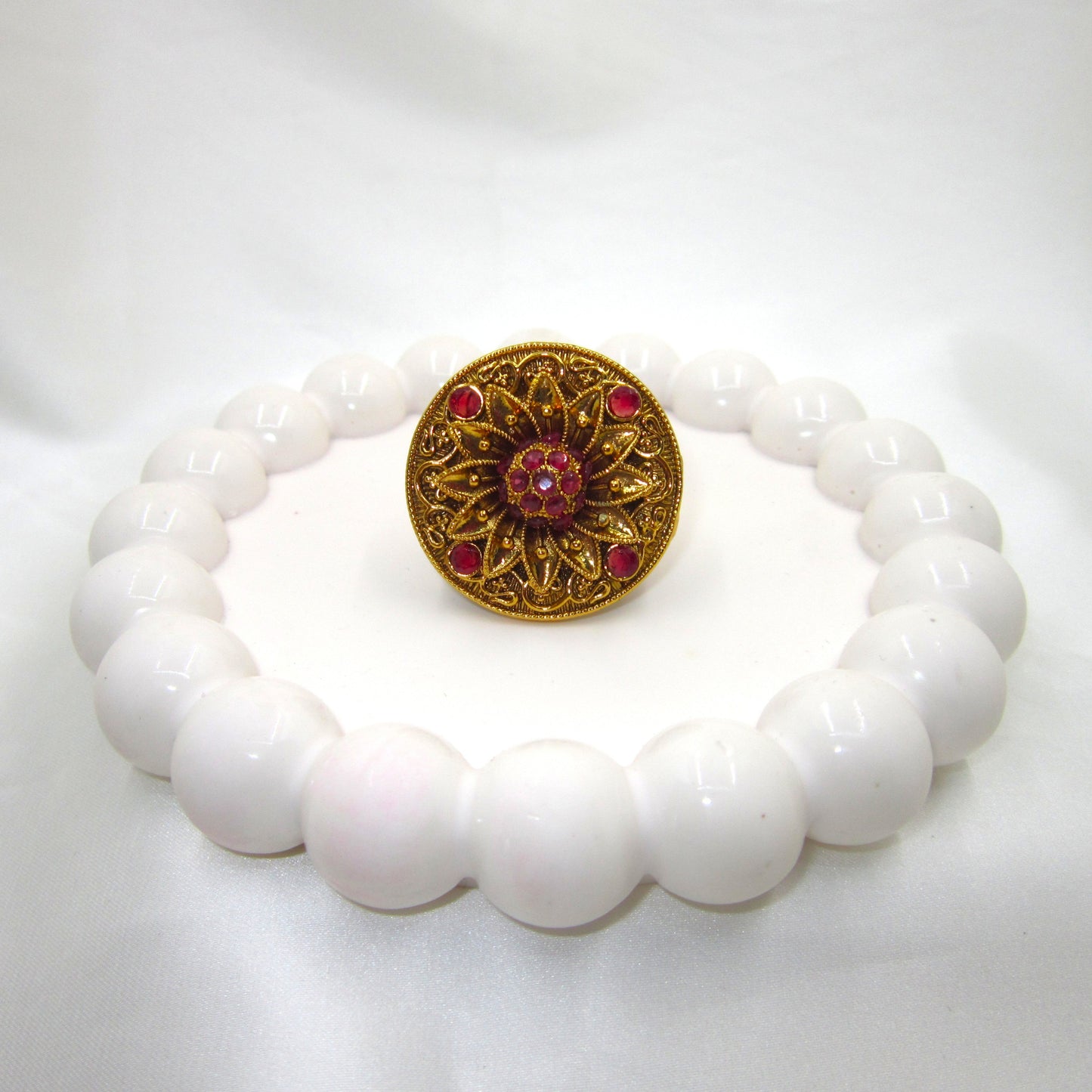 Swarna Petals Ruby Pink Antique Finish Ring by Enava featuring a handcrafted floral sunburst design with antique gold finish and ruby pink stones, traditional ethnic statement ring for women, ideal for weddings, festive wear, Rajwadi jewellery, and bridal accessories.