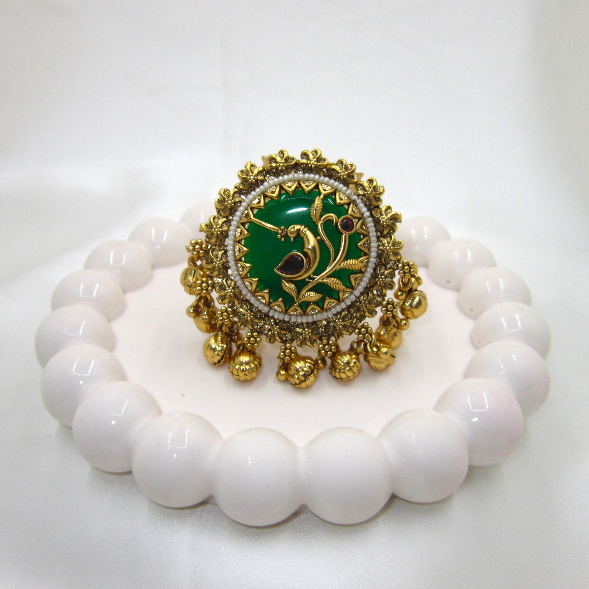 Vanmayuri Heritage Antique Emerald Green Ghungroo Ring by Enava featuring an adjustable antique gold statement ring with emerald green enamel, floral vine design, pearl border and decorative ghungroo charms, perfect for wedding jewellery, festive wear and traditional ethnic outfits.