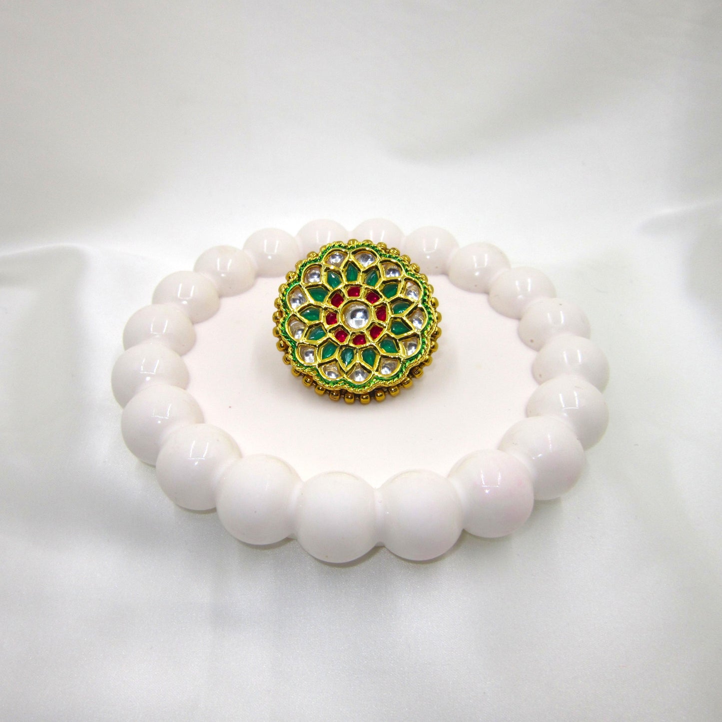 Vrinda Ethnic & Traditional Kundan Ring by Enava featuring white kundan stones, green enamel petals, ruby-pink accents, and gold plating in a floral statement design for ethnic, festive, and wedding wear.