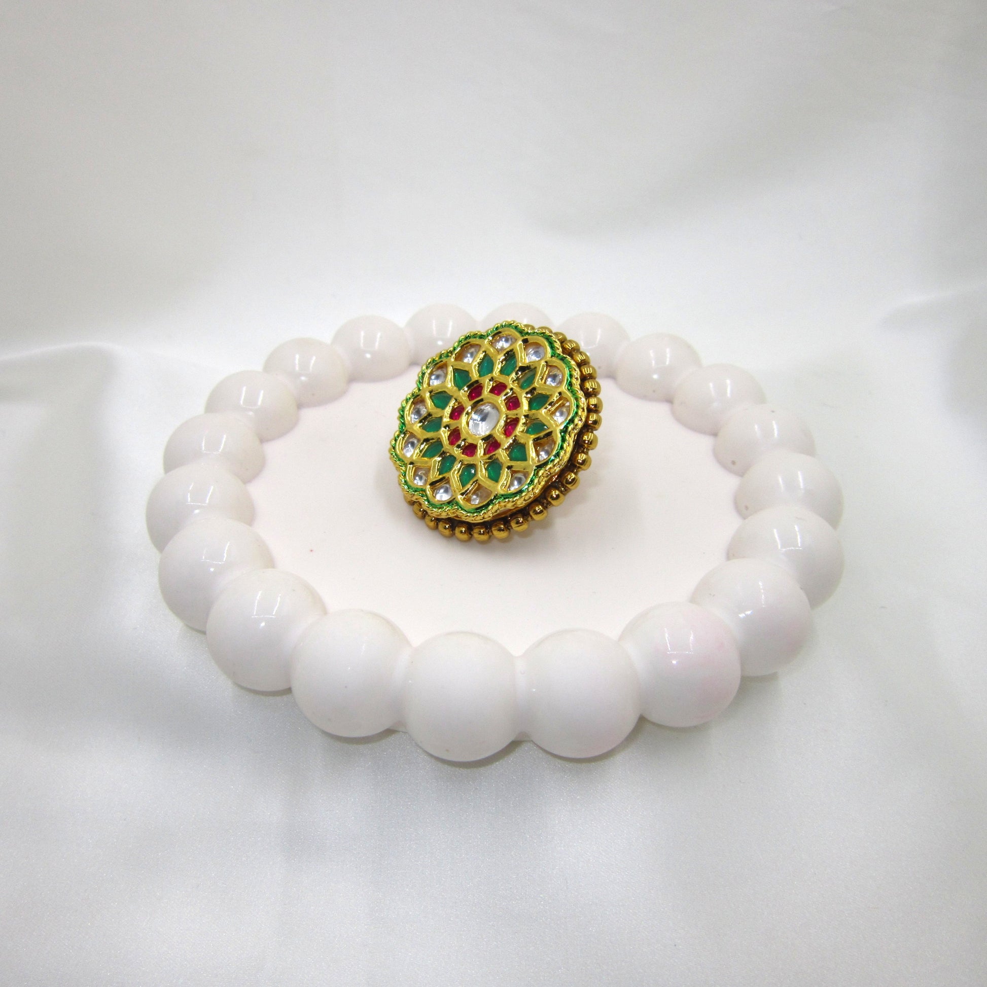 Vrinda Ethnic & Traditional Kundan Ring by Enava featuring white kundan stones, green enamel petals, ruby-pink accents, and gold plating in a floral statement design for ethnic, festive, and wedding wear.