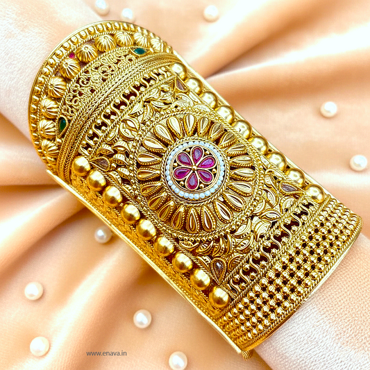 Enava Maharani Rajputana Long Kada, a masterpiece inspired by timeless royal heritage jewelry. Crafted with intricate traditional detailing, this broad Rajwadi kada features elegant floral motifs, antique gold finish, and luxurious handcrafted patterns that reflect the grandeur of Rajputana culture.

Designed for brides, festive occasions, weddings, and royal ethnic styling, this statement kada beautifully complements lehengas, sarees, and traditional outfits. Its bold long-cuff design adds a majestic touch