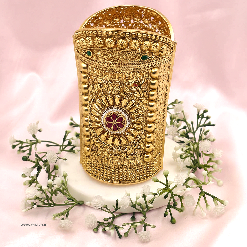 Enava Maharani Rajputana Long Kada, a masterpiece inspired by timeless royal heritage jewelry. Crafted with intricate traditional detailing, this broad Rajwadi kada features elegant floral motifs, antique gold finish, and luxurious handcrafted patterns that reflect the grandeur of Rajputana culture.

Designed for brides, festive occasions, weddings, and royal ethnic styling, this statement kada beautifully complements lehengas, sarees, and traditional outfits. Its bold long-cuff design adds a majestic touch